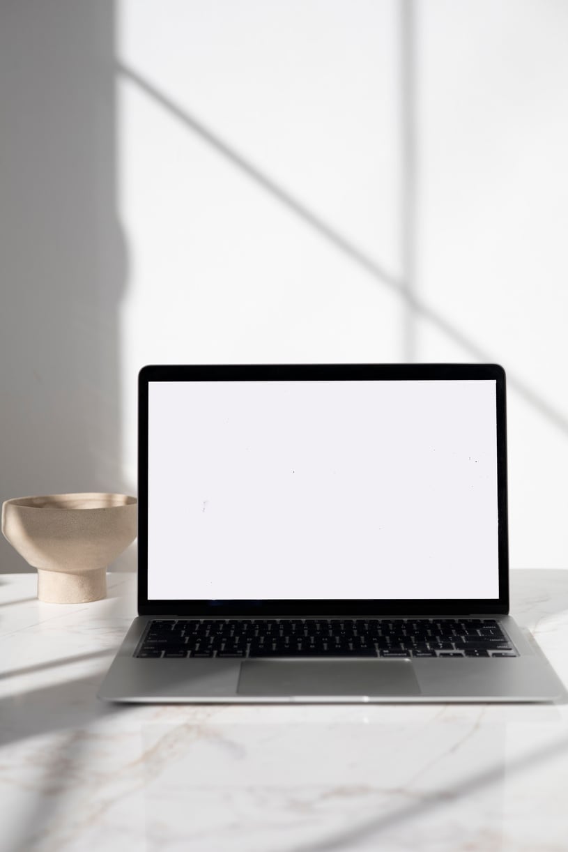 A Laptop with a Blank Screen on a Marble Surface